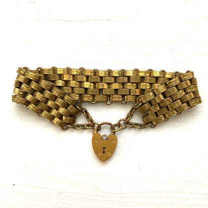 A bracelet featuring a heart-shaped padlock set on a heavy wide link chain. 重厚感のあるワイドリンクチェーンに、ハート型のパッドロックをあしらったブレスレット。