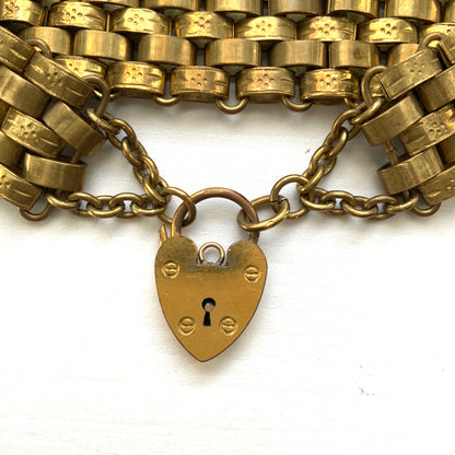 A bracelet featuring a heart-shaped padlock set on a heavy wide link chain. 重厚感のあるワイドリンクチェーンに、ハート型のパッドロックをあしらったブレスレット。