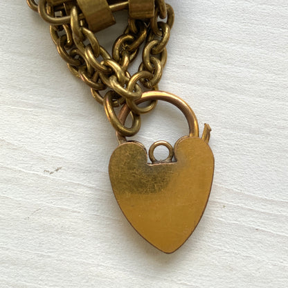 A bracelet featuring a heart-shaped padlock set on a heavy wide link chain. 重厚感のあるワイドリンクチェーンに、ハート型のパッドロックをあしらったブレスレット。