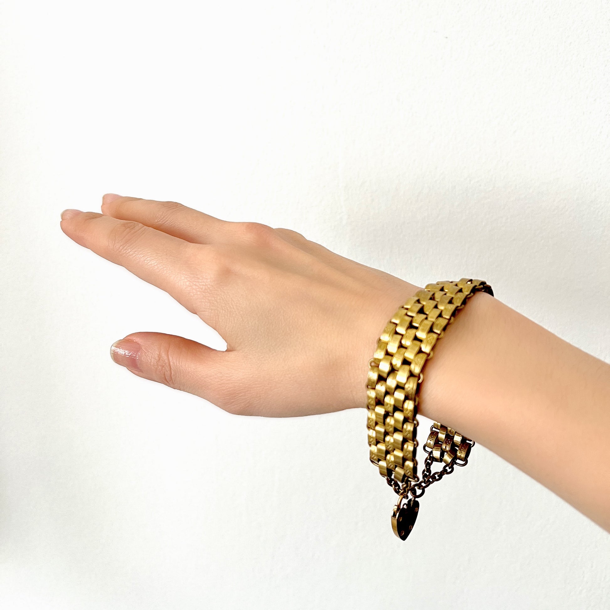 A bracelet featuring a heart-shaped padlock set on a heavy wide link chain. 重厚感のあるワイドリンクチェーンに、ハート型のパッドロックをあしらったブレスレット。