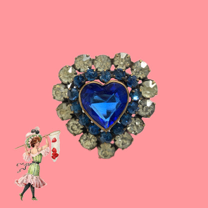 A charming heart-shaped mini brooch featuring a deep sea-blue glass centre. 深い海を思わせるブルーグラスが印象的な、ハートモチーフのミニブローチ。
