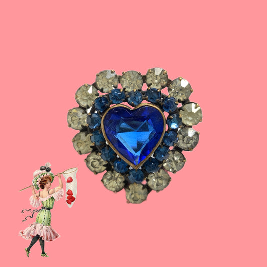 A charming heart-shaped mini brooch featuring a deep sea-blue glass centre. 深い海を思わせるブルーグラスが印象的な、ハートモチーフのミニブローチ。