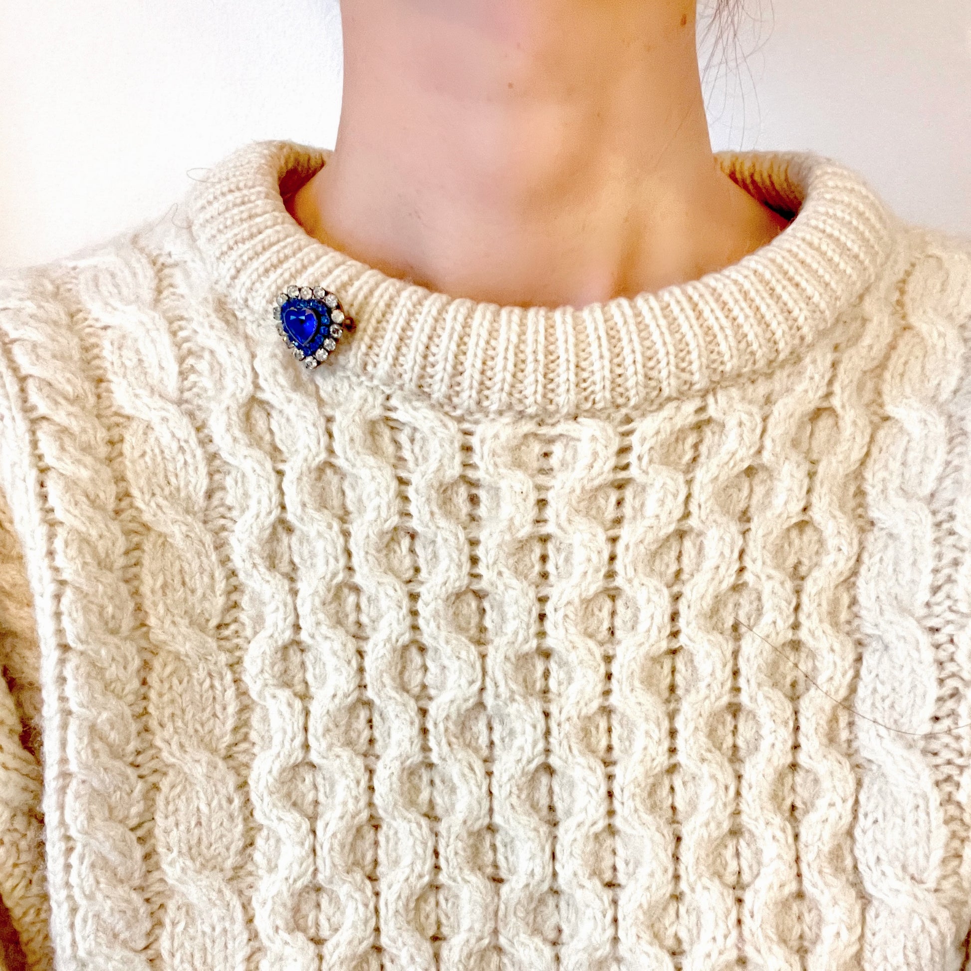 A charming heart-shaped mini brooch featuring a deep sea-blue glass centre. 深い海を思わせるブルーグラスが印象的な、ハートモチーフのミニブローチ。