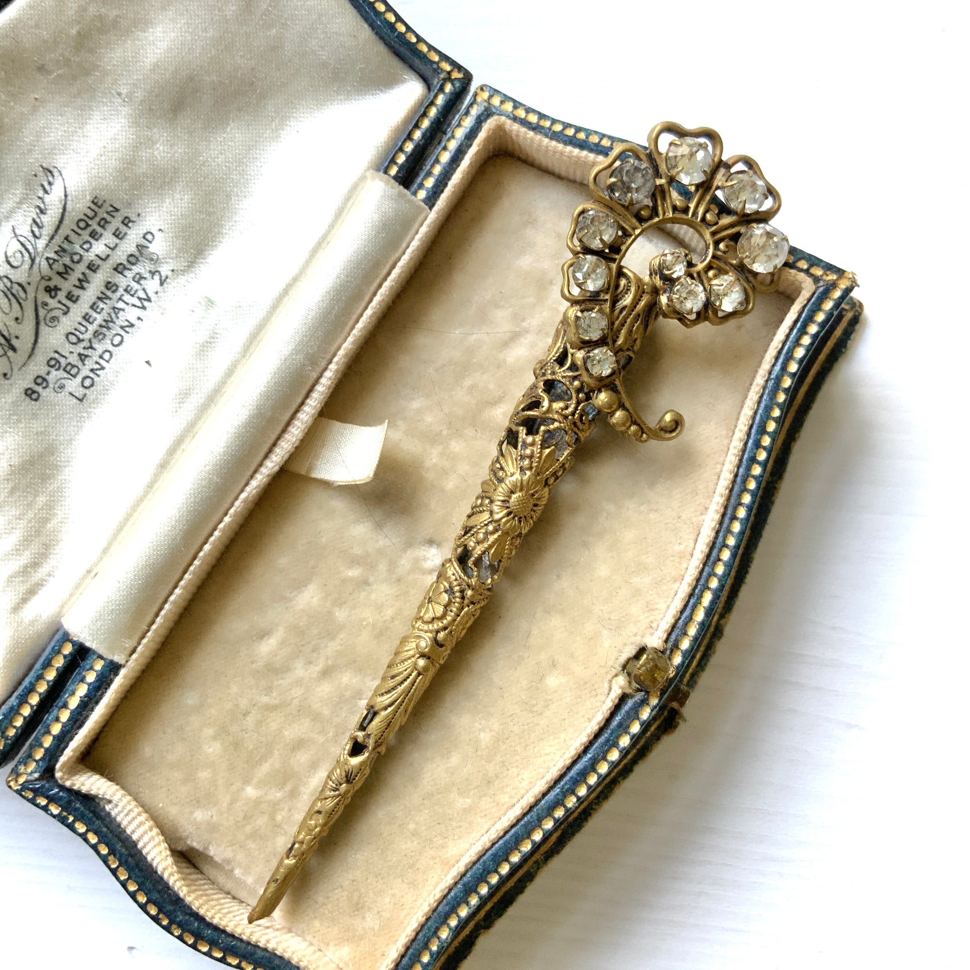 A decorative posy holder crafted from gold-tone filigree and adorned with sparkling rhinestones. ゴールドトーンのフィリグリーにラインストーンがあしらわれた、装飾的なポージーホルダー。