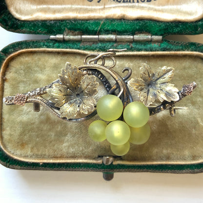 An antique silver brooch featuring a white grape motif set with frosted glass. アンティークのフロストグラスを使った白ブドウモチーフのシルバーブローチ。