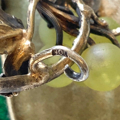 An antique silver brooch featuring a white grape motif set with frosted glass. アンティークのフロストグラスを使った白ブドウモチーフのシルバーブローチ。