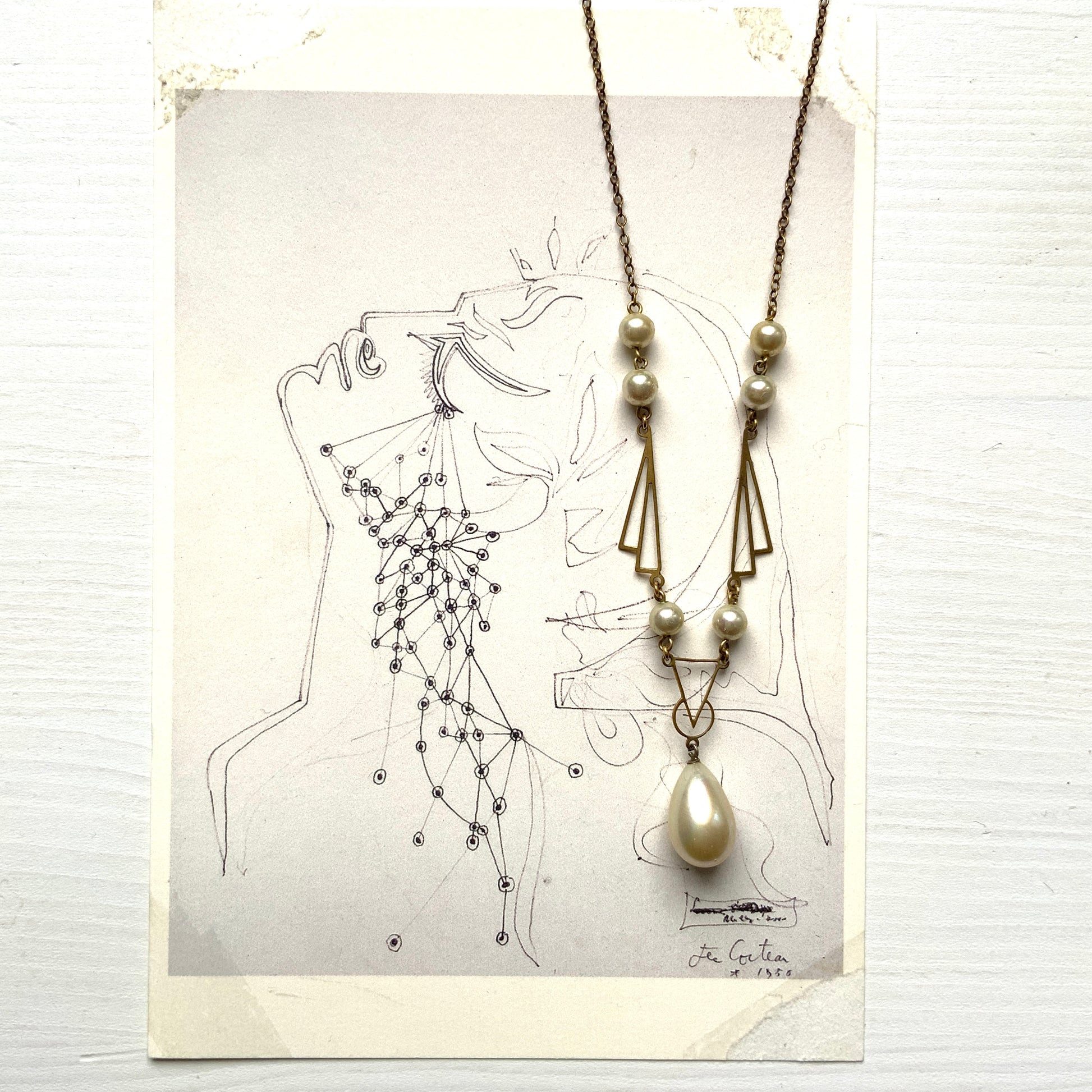 A necklace combining gold-tone metal links and glass pearls. ゴールドトーンメタルのリンクとグラスパールを組み合わせたネックレス。