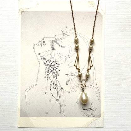 A necklace combining gold-tone metal links and glass pearls. ゴールドトーンメタルのリンクとグラスパールを組み合わせたネックレス。