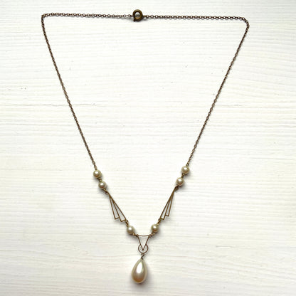 A necklace combining gold-tone metal links and glass pearls. ゴールドトーンメタルのリンクとグラスパールを組み合わせたネックレス。