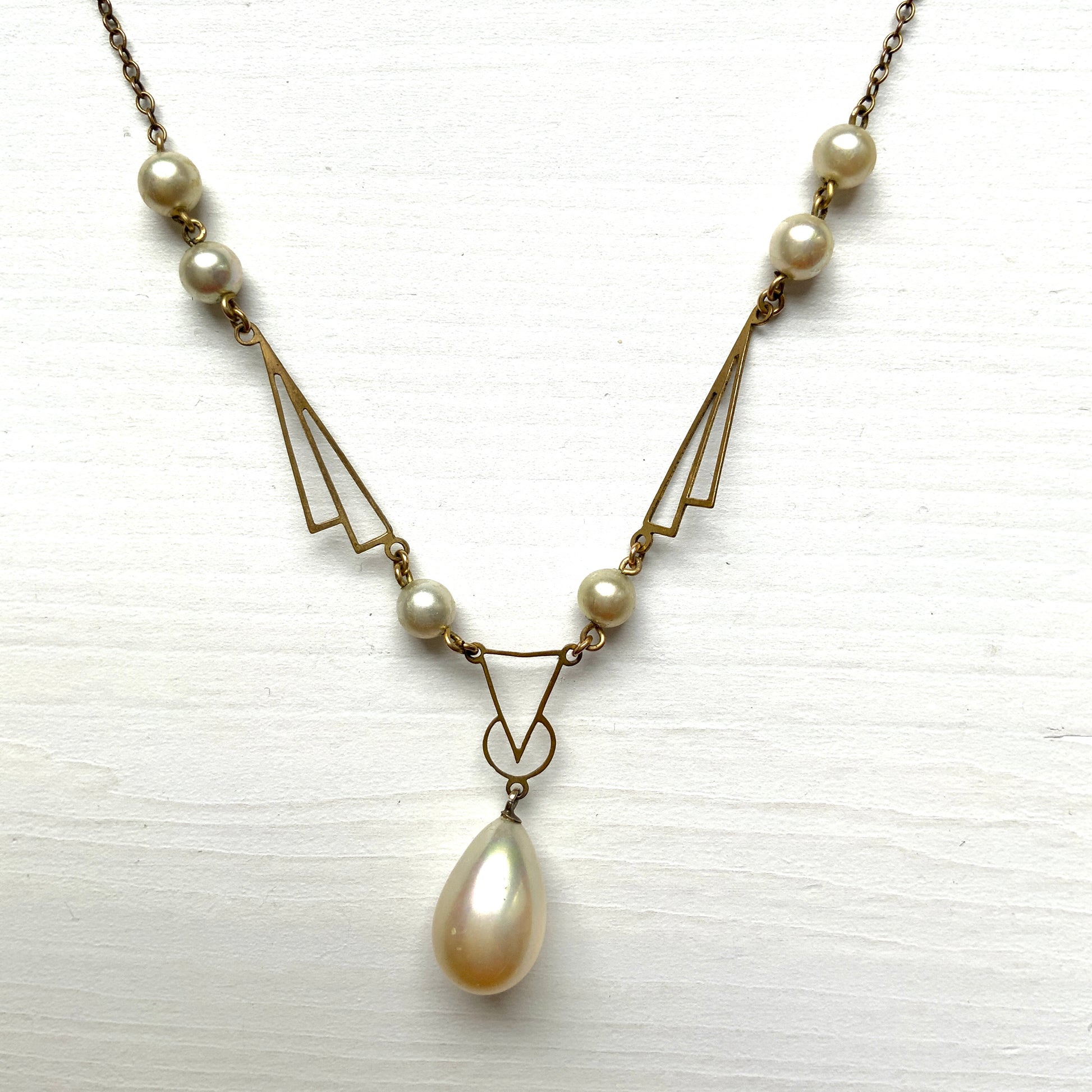 A necklace combining gold-tone metal links and glass pearls. ゴールドトーンメタルのリンクとグラスパールを組み合わせたネックレス。