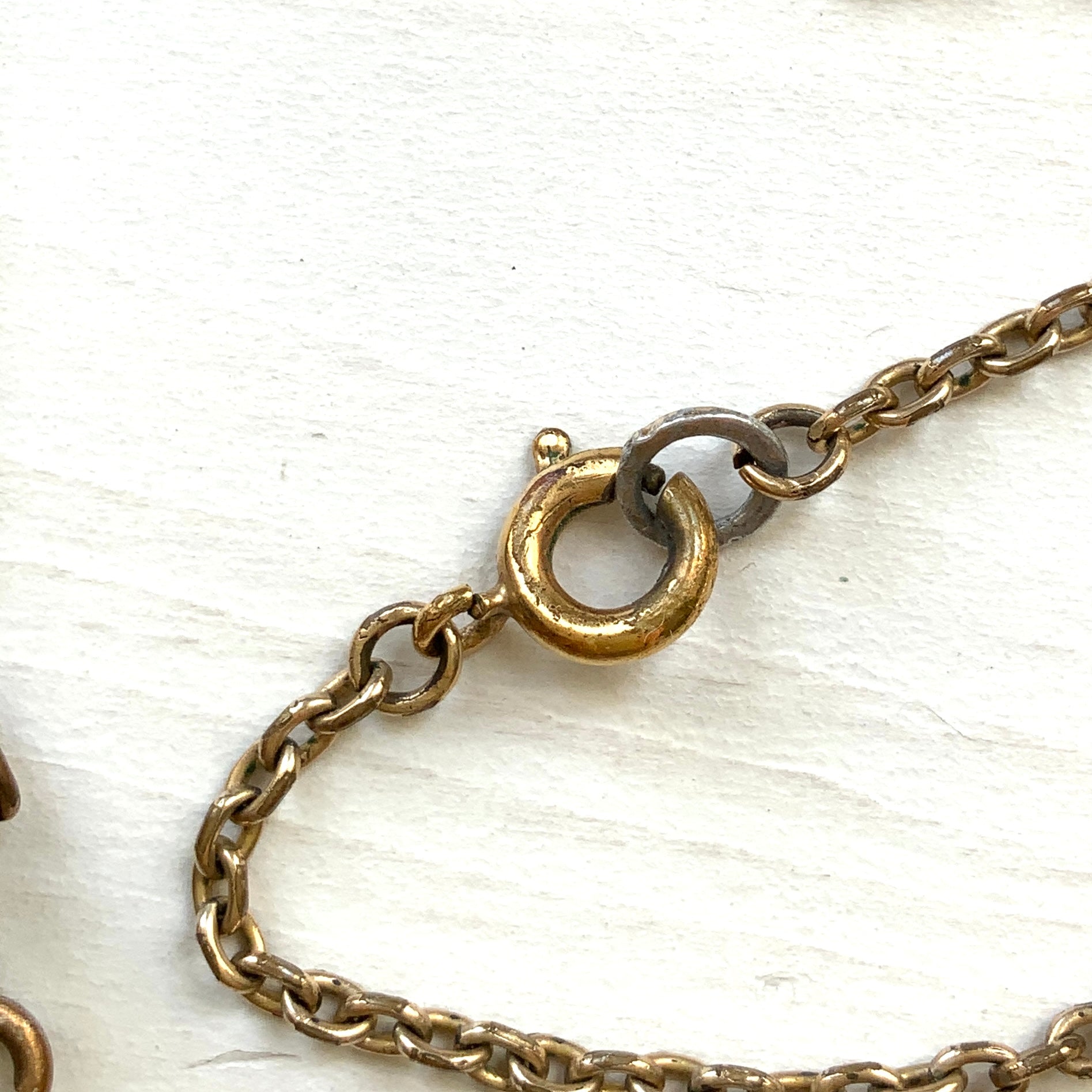 An antique pendant necklace featuring a starburst design with a mysterious glass stone known as Saphiret set in the centre. 神秘的な輝きを放つサフィレットを中央に添えた、ラインストーンのスターバーストデザインのペンダントネックレス。