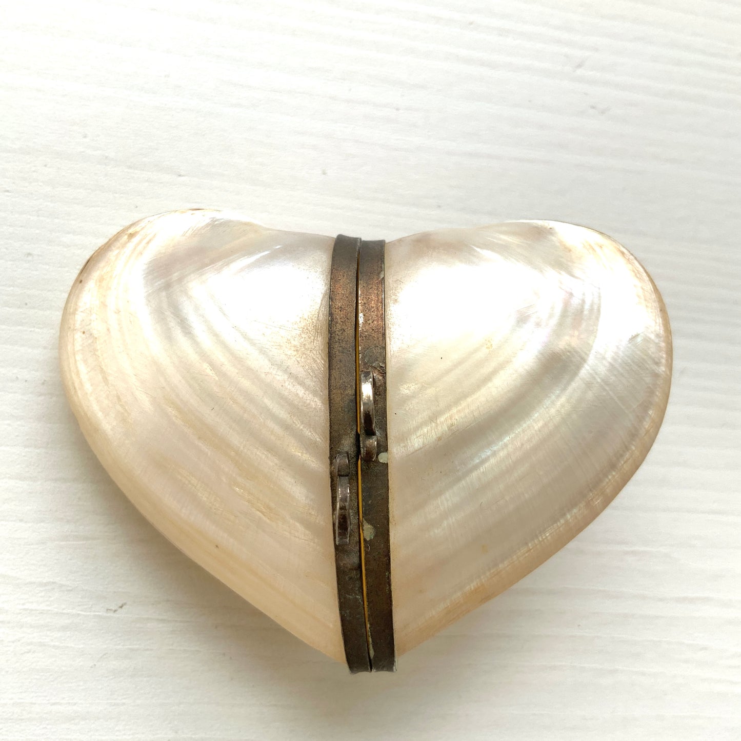 A small heart-shaped box made from mother of pearl. マザーオブパールでできた、ハート型の小さなボックスケース。