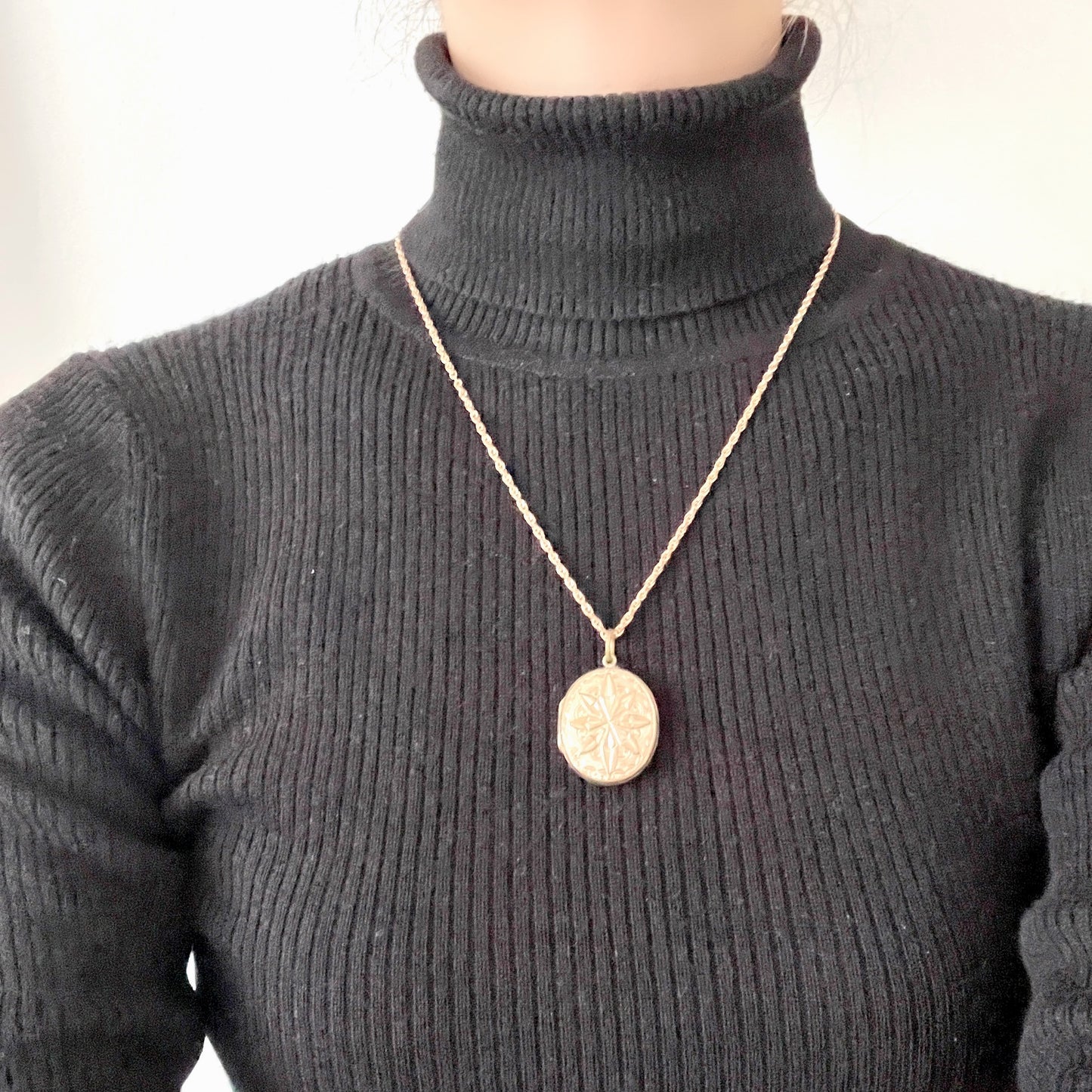 A rolled gold locket pendant necklace featuring a beautifully embossed starburst motif. スターバーストモチーフが立体的にエンボスされた、ロールドゴールドのロケットペンダントネックレス。