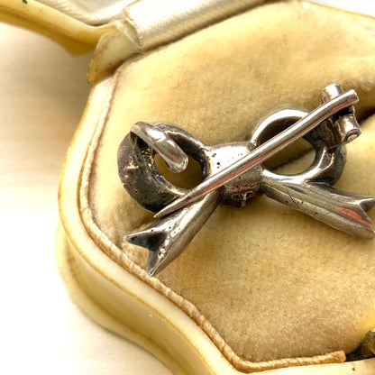 A small silver bow brooch set with rhinestones. ラインストーンがあしらわれた小さなリボンのシルバーブローチ。