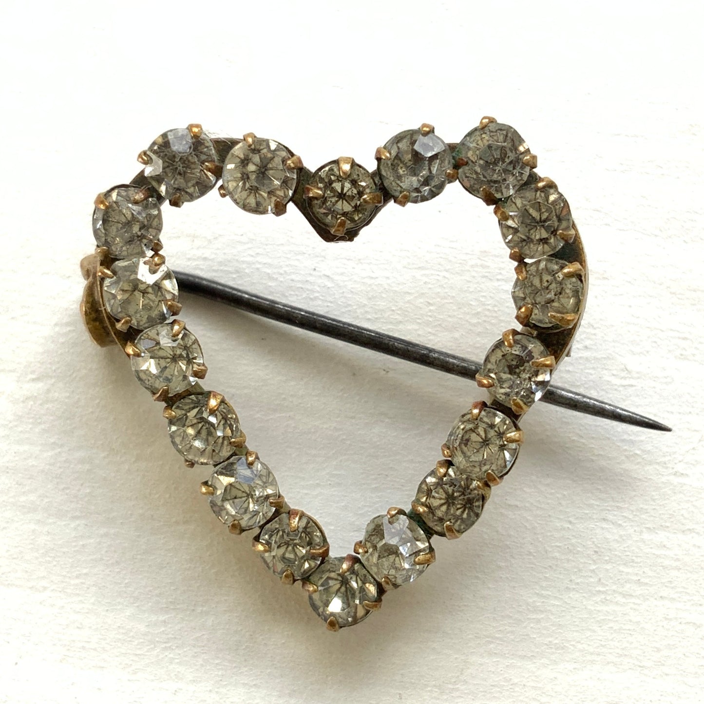 A mini open-heart brooch set with clear rhinestones. クリアラインストーンを連ねた、オープンハートのミニブローチ。