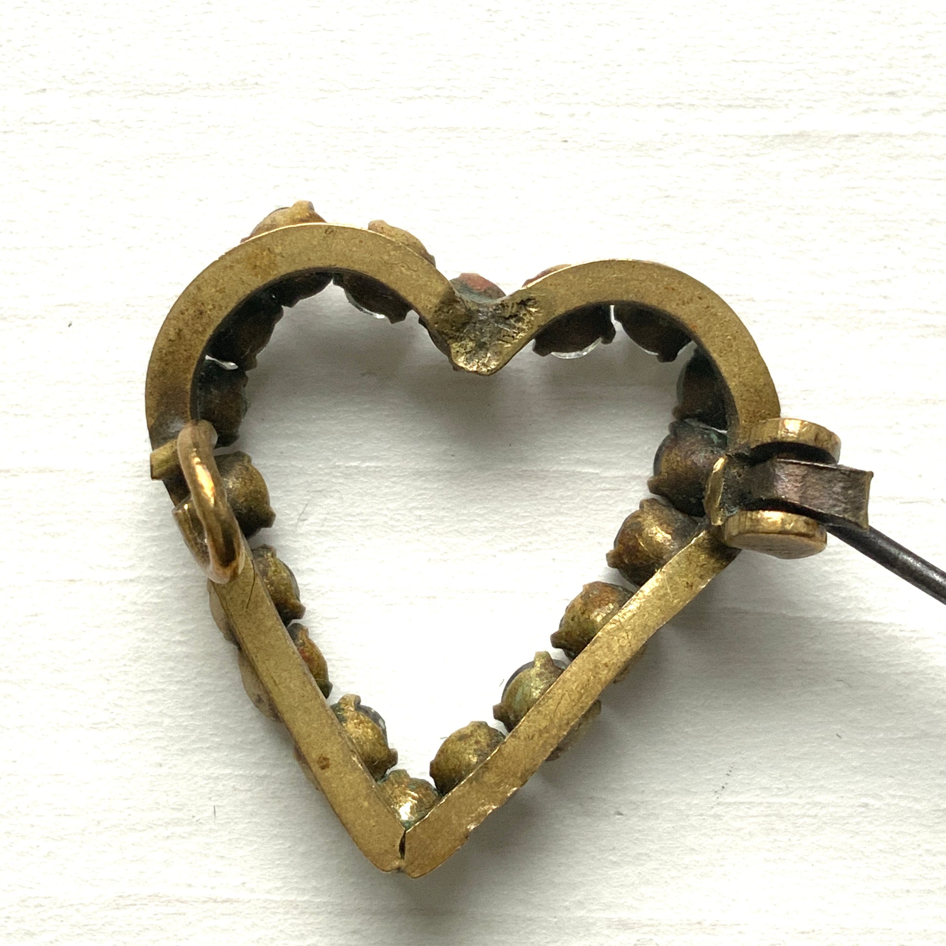 A mini open-heart brooch set with clear rhinestones. クリアラインストーンを連ねた、オープンハートのミニブローチ。