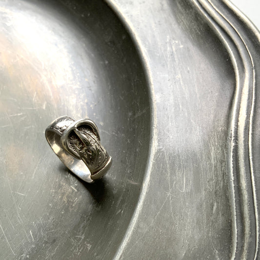 Silver belt & buckle motif ring. The engraved details resemble botanical motifs. シルバーのベルト＆バックルモチーフのリング。 植物モチーフのような彫り模様も見られます。 