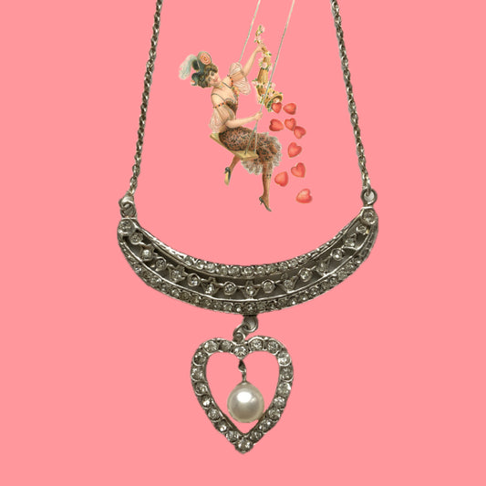 A silver pendant necklace featuring a crescent bar and heart motif.  クレセントバーとハートモチーフのシルバーペンダントネックレス。 