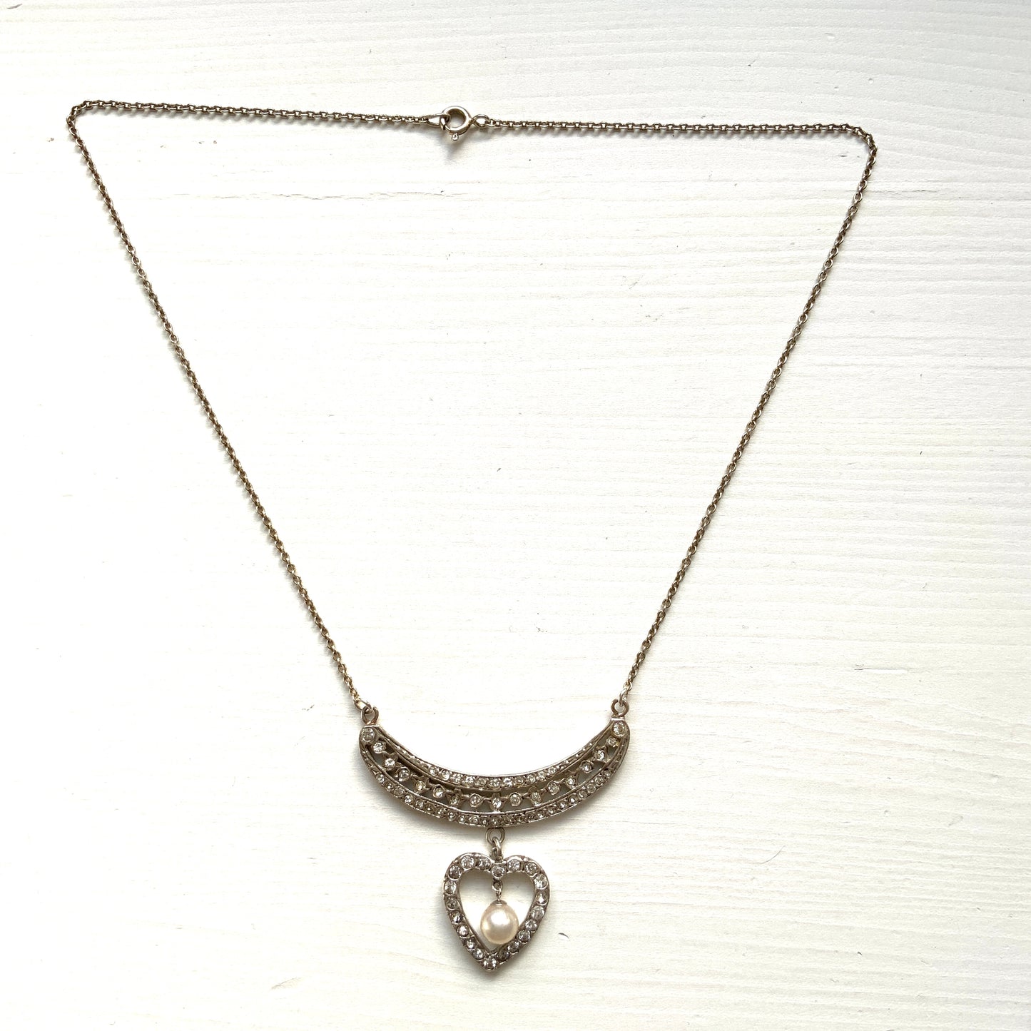 A silver pendant necklace featuring a crescent bar and heart motif.  クレセントバーとハートモチーフのシルバーペンダントネックレス。 