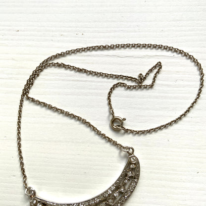 A silver pendant necklace featuring a crescent bar and heart motif.  クレセントバーとハートモチーフのシルバーペンダントネックレス。 