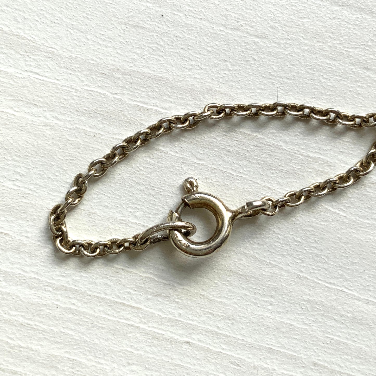 A silver pendant necklace featuring a crescent bar and heart motif.  クレセントバーとハートモチーフのシルバーペンダントネックレス。 