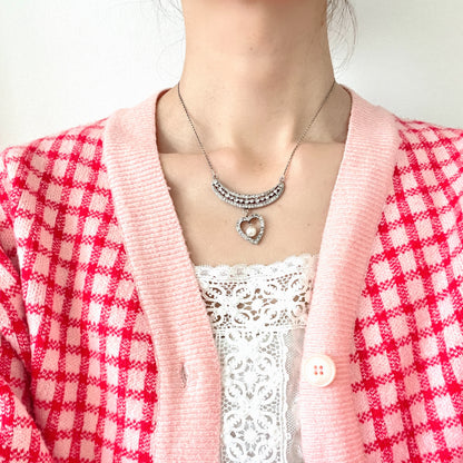 A silver pendant necklace featuring a crescent bar and heart motif.  クレセントバーとハートモチーフのシルバーペンダントネックレス。 