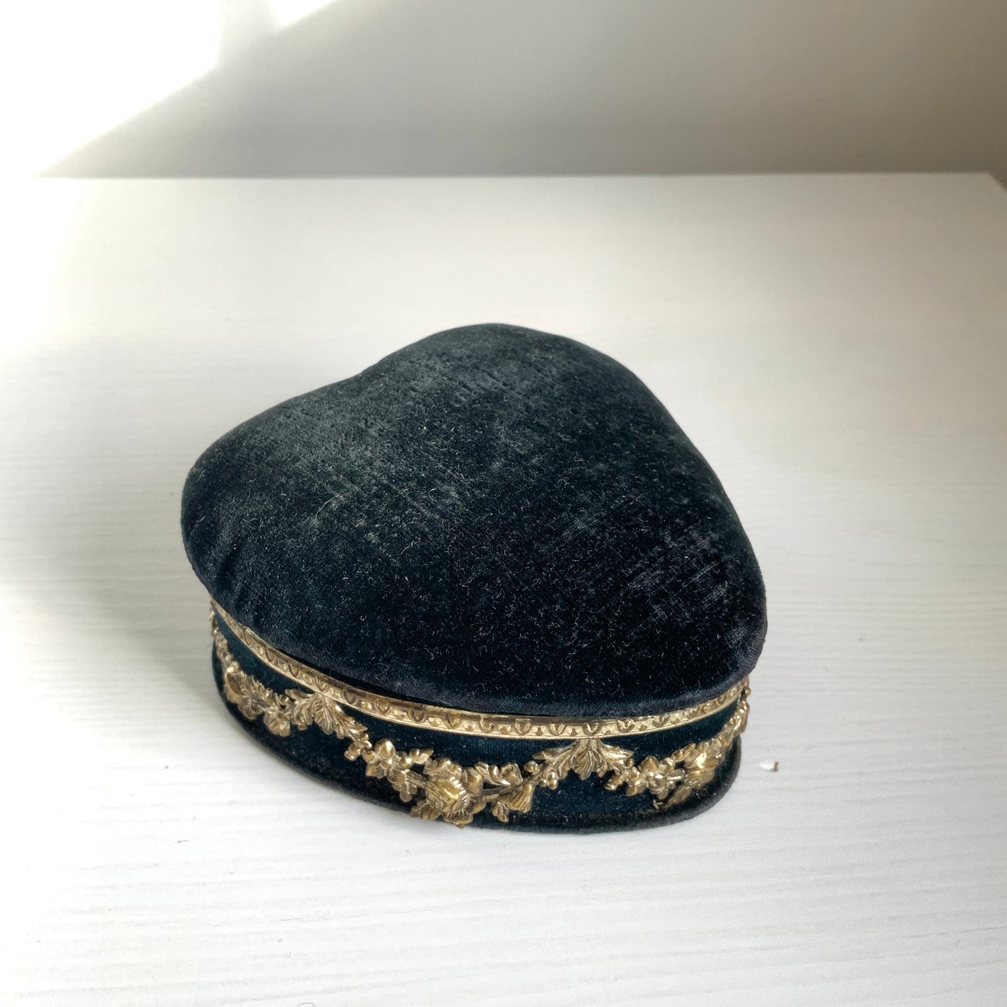 A heart-shaped trinket box featuring delicate silver-tone decoration set against black velvet.  ブラックのベルベットに、繊細なシルバートーンの装飾が映えるハート型の小箱。