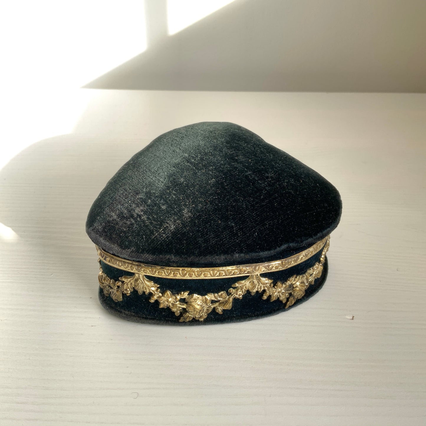 A heart-shaped trinket box featuring delicate silver-tone decoration set against black velvet.  ブラックのベルベットに、繊細なシルバートーンの装飾が映えるハート型の小箱。