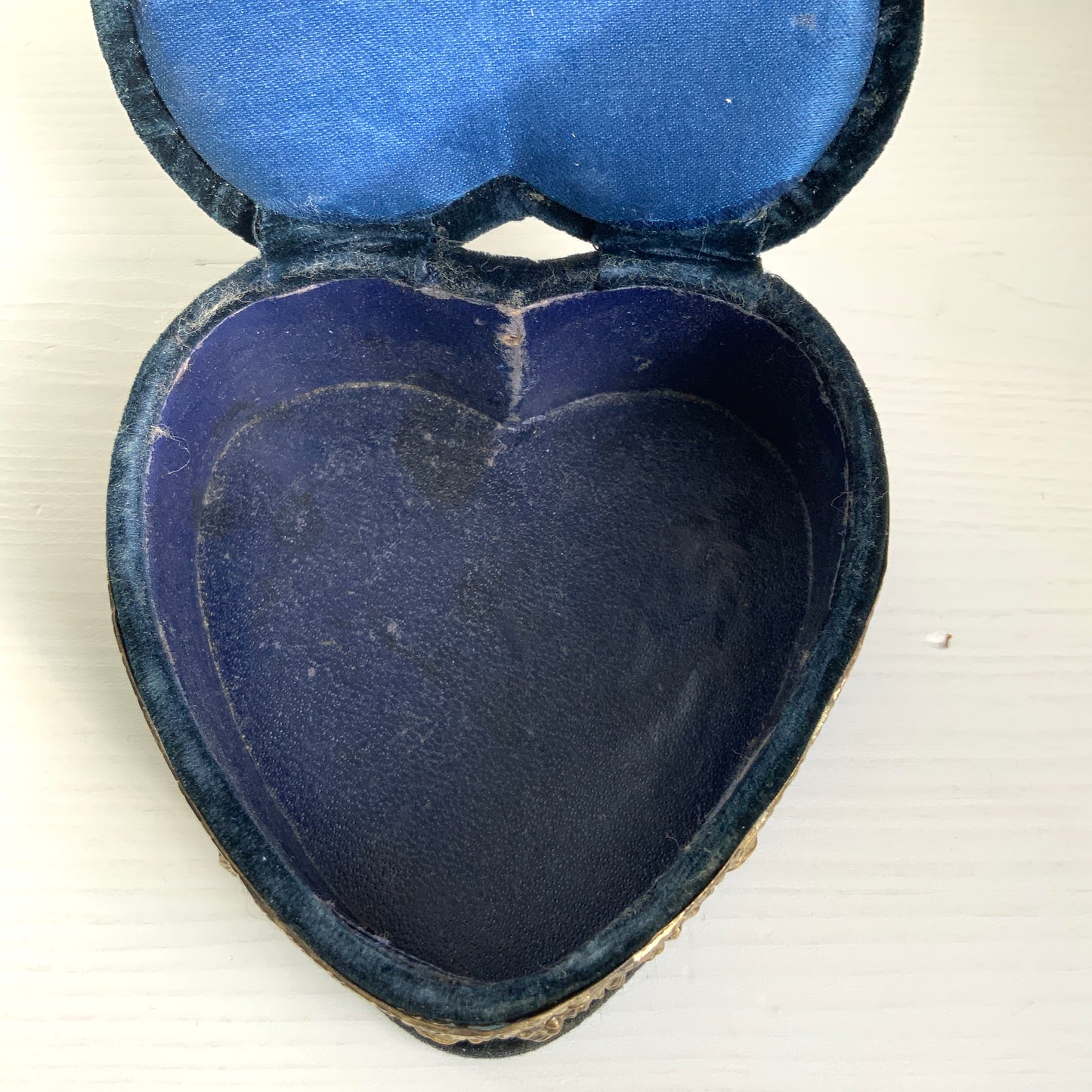 A heart-shaped trinket box featuring delicate silver-tone decoration set against black velvet.  ブラックのベルベットに、繊細なシルバートーンの装飾が映えるハート型の小箱。
