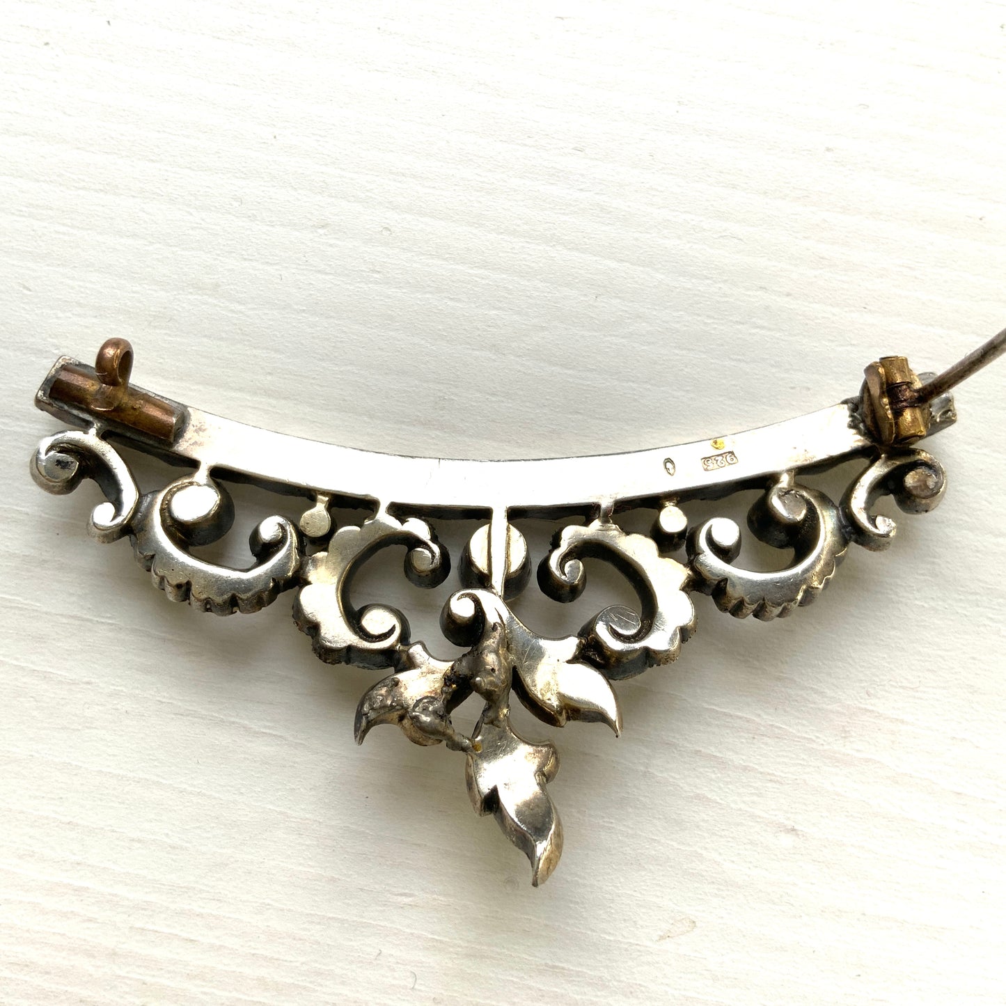 A vintage rhinestone brooch with flowing leaf-like motifs and a gentle curved silhouette.  ラインストーンが連なり、葉っぱのようなモチーフがしなやかに広がるヴィンテージブローチ。 