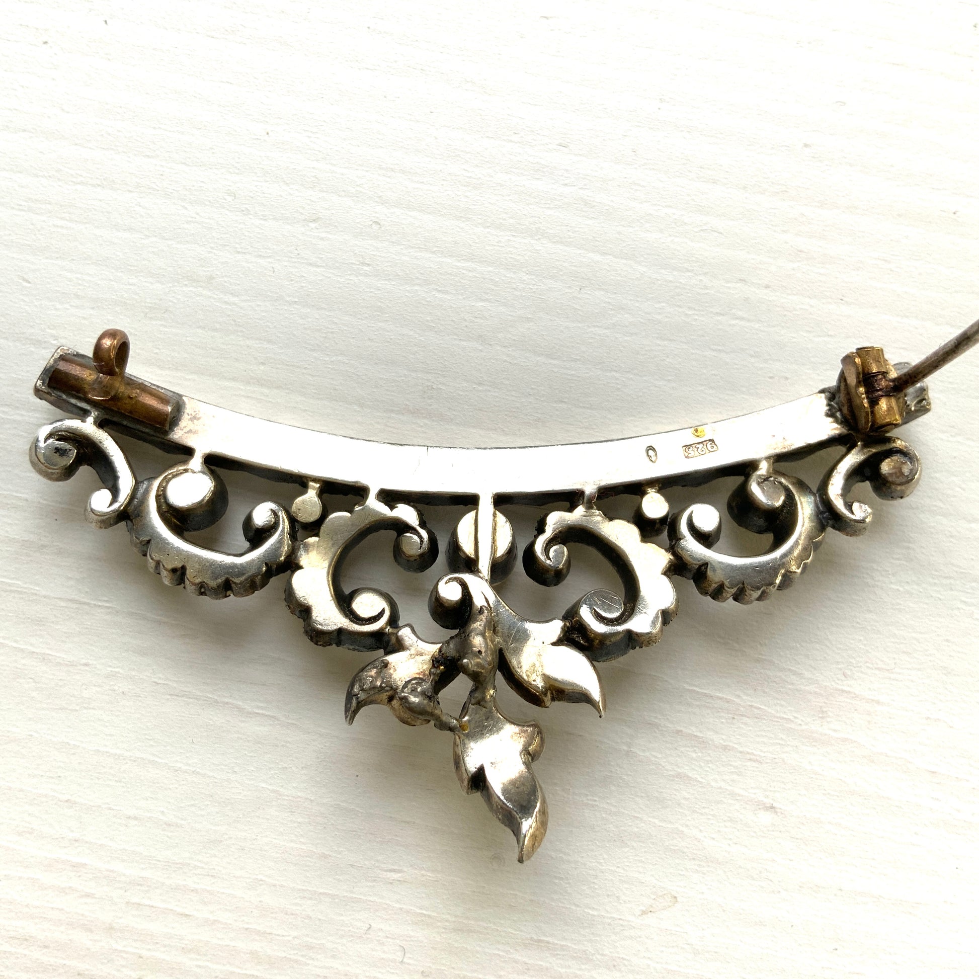 A vintage rhinestone brooch with flowing leaf-like motifs and a gentle curved silhouette.  ラインストーンが連なり、葉っぱのようなモチーフがしなやかに広がるヴィンテージブローチ。 