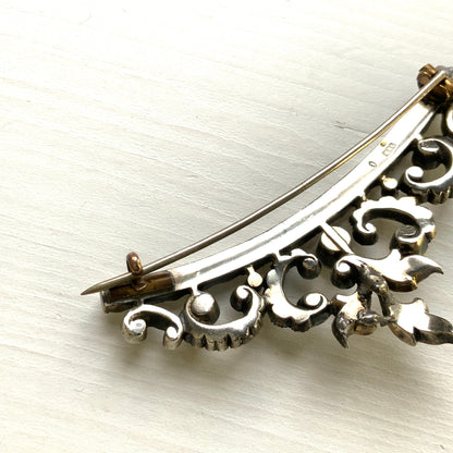 A vintage rhinestone brooch with flowing leaf-like motifs and a gentle curved silhouette.  ラインストーンが連なり、葉っぱのようなモチーフがしなやかに広がるヴィンテージブローチ。 