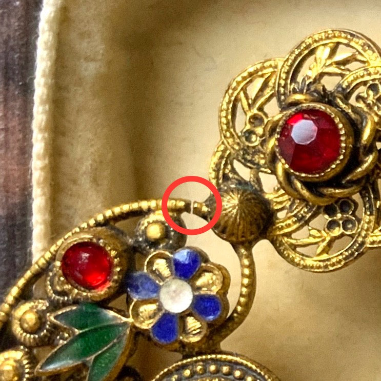 A buckle-style brooch composed of various filigree plates, adorned with colourful rhinestones and enamel details.  様々な形のフィリグリー プレートを繋げ、そこにカラフルなラインストーン やエナメル をあしらったバックル型のブローチ。