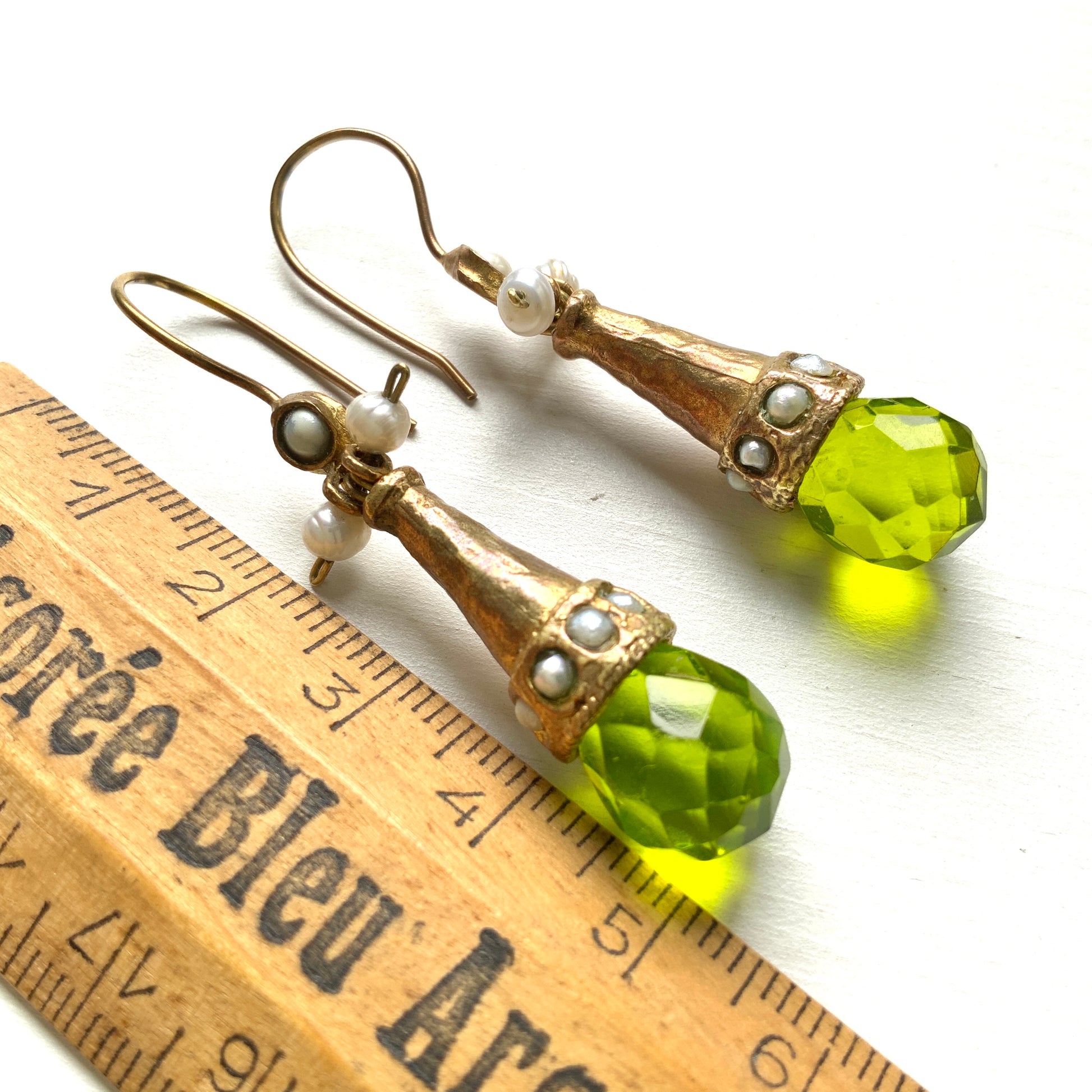 Earrings featuring a tapered gold-tone setting with vivid lime green glass. 円錐状のゴールドトーンに、鮮やかなライムグリーングラスが輝くピアス。 