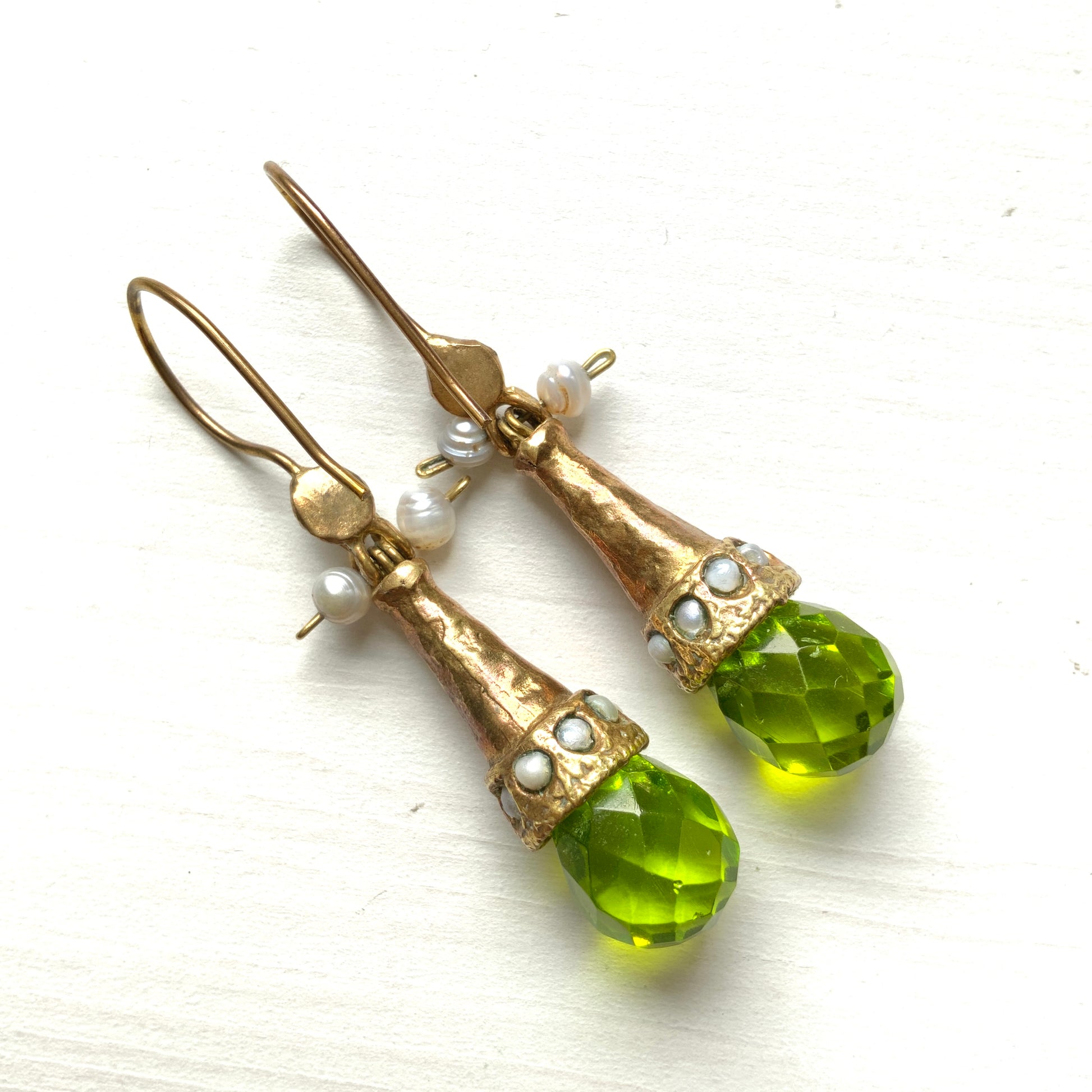 Earrings featuring a tapered gold-tone setting with vivid lime green glass. 円錐状のゴールドトーンに、鮮やかなライムグリーングラスが輝くピアス。 