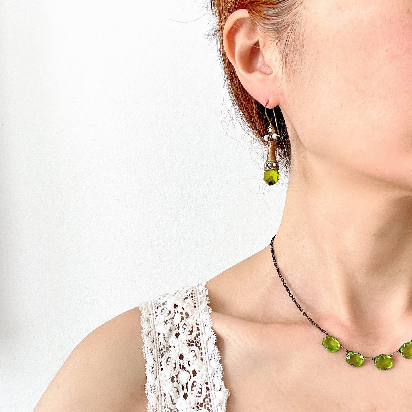 Earrings featuring a tapered gold-tone setting with vivid lime green glass. 円錐状のゴールドトーンに、鮮やかなライムグリーングラスが輝くピアス。 