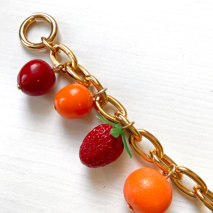A bracelet featuring plastic fruit charms. プラスチックのフルーツチャームのブレスレット。