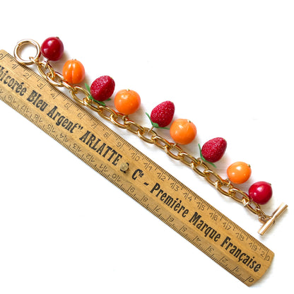 A bracelet featuring plastic fruit charms. プラスチックのフルーツチャームのブレスレット。