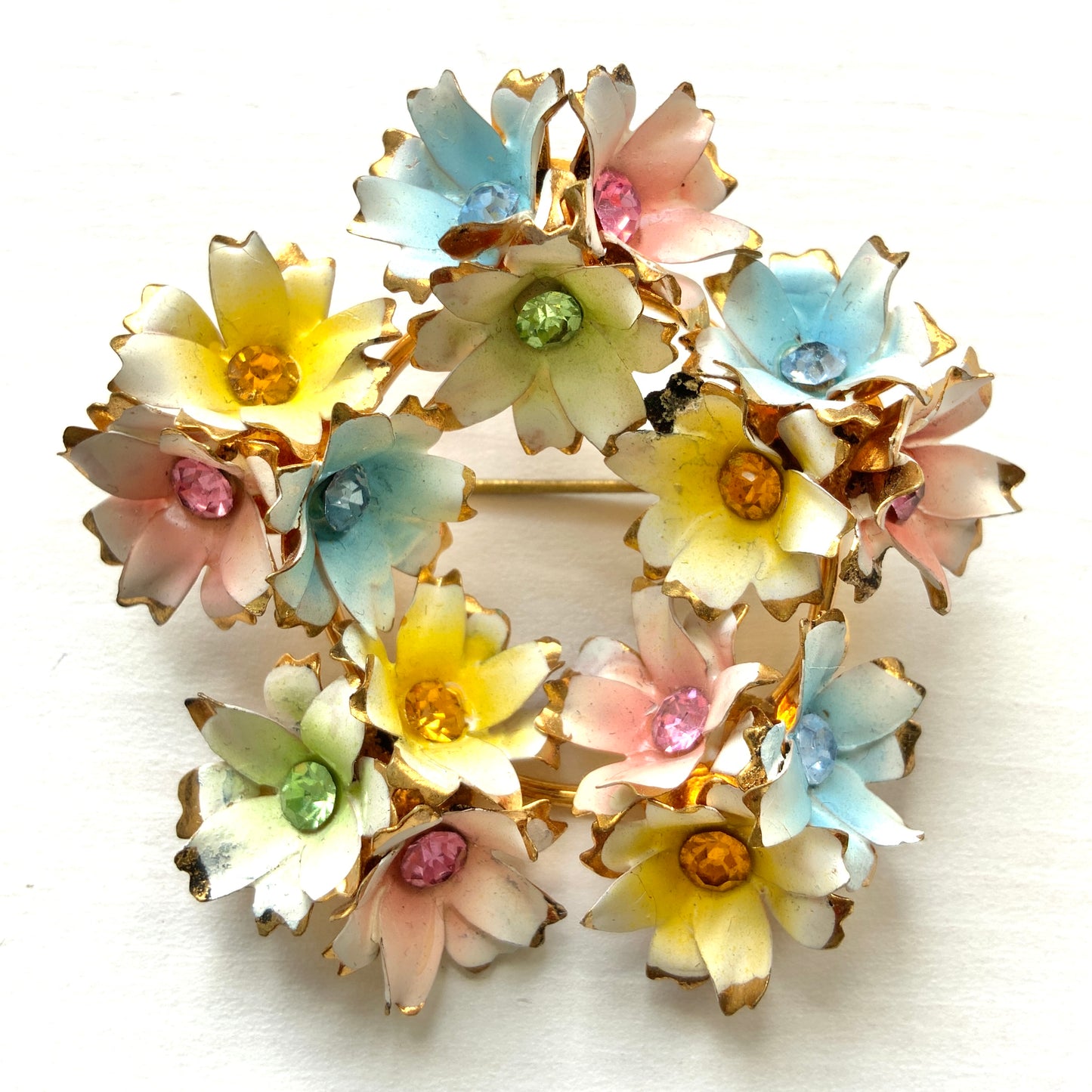 Vintage 1950s brooch featuring pastel enamel flowers arranged in a wreath design. パステルカラーのエナメルフラワーをリース状にあしらった、1950年代のヴィンテージブローチ。
