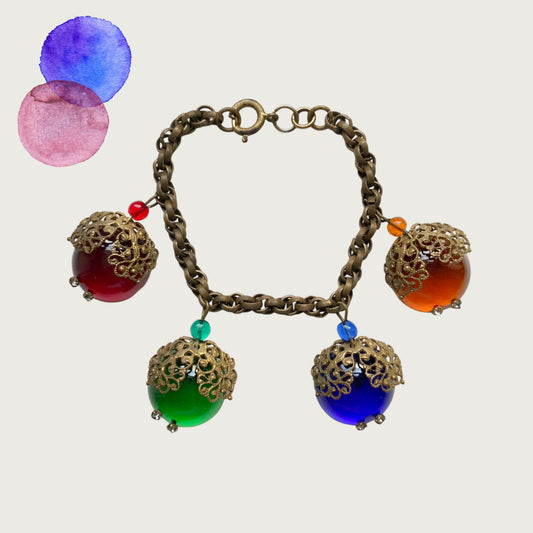 A vintage charm bracelet featuring colourful glass cabochon charms. カラフルなカボションガラスチャームが揺れる、ヴィンテージチャームブレスレット。