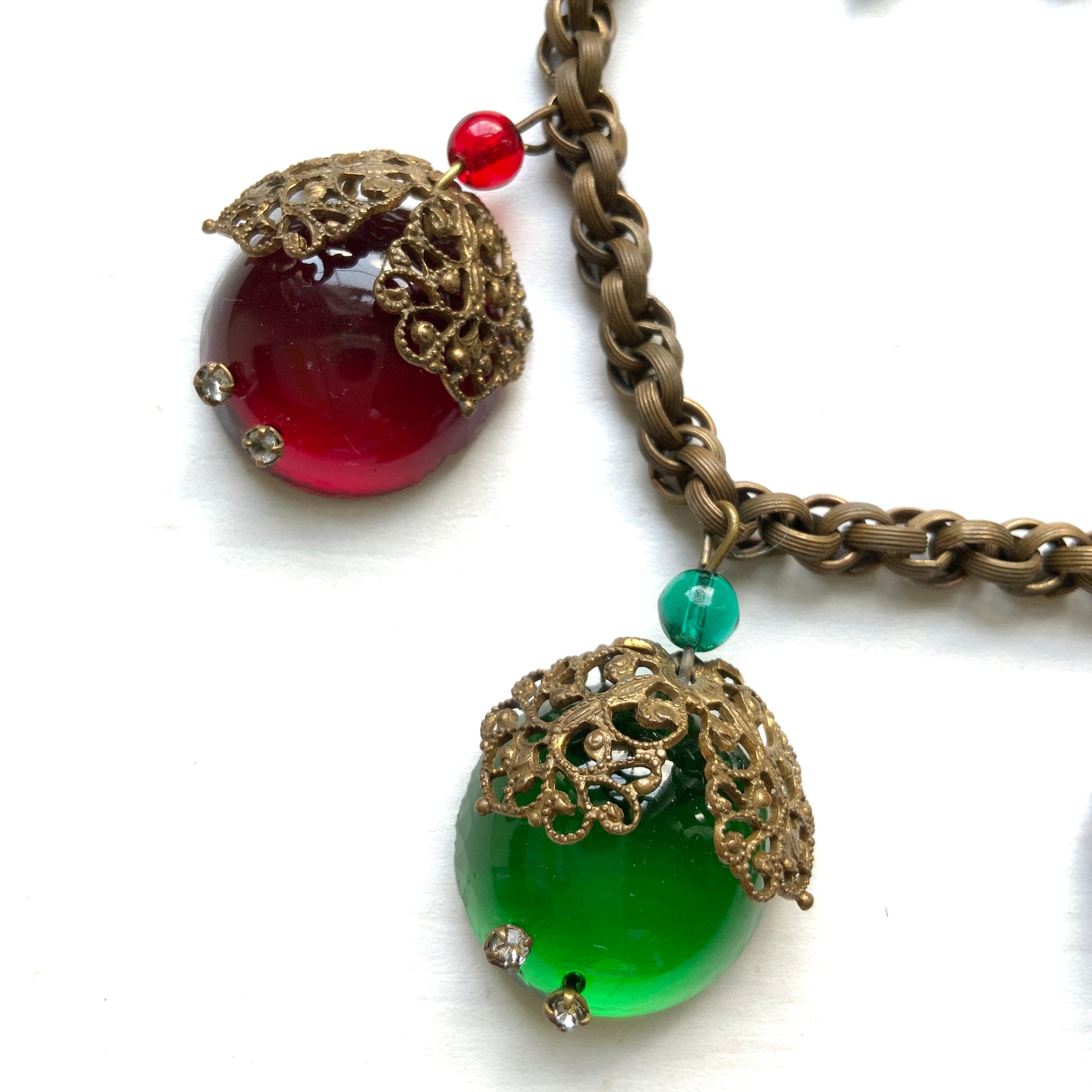 A vintage charm bracelet featuring colourful glass cabochon charms. カラフルなカボションガラスチャームが揺れる、ヴィンテージチャームブレスレット。