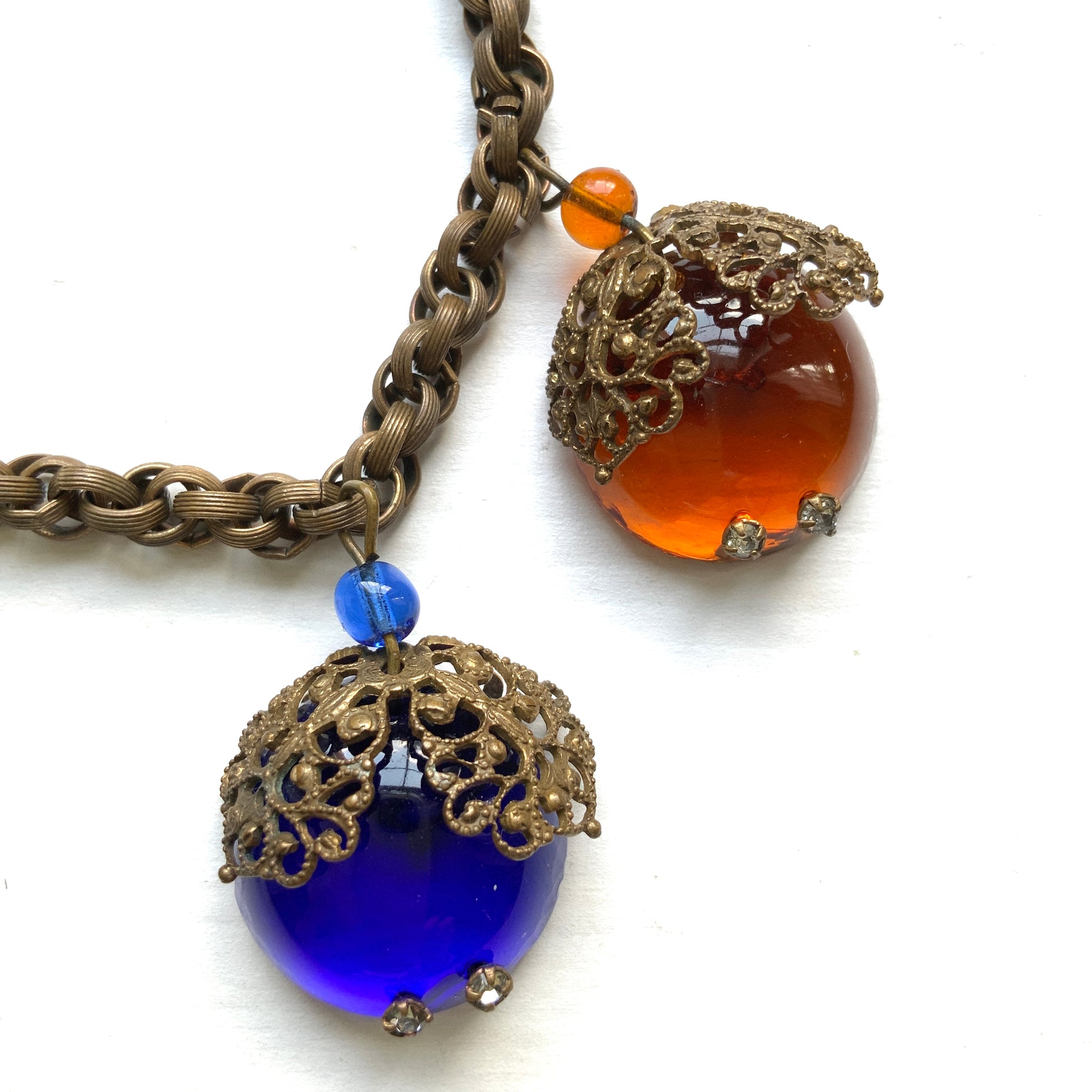 A vintage charm bracelet featuring colourful glass cabochon charms. カラフルなカボションガラスチャームが揺れる、ヴィンテージチャームブレスレット。