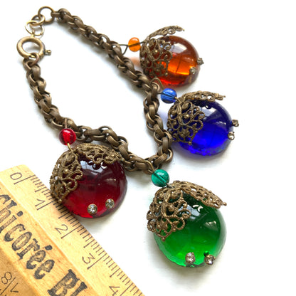 A vintage charm bracelet featuring colourful glass cabochon charms. カラフルなカボションガラスチャームが揺れる、ヴィンテージチャームブレスレット。
