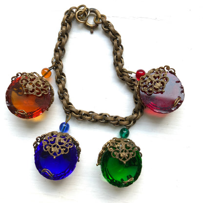 A vintage charm bracelet featuring colourful glass cabochon charms. カラフルなカボションガラスチャームが揺れる、ヴィンテージチャームブレスレット。