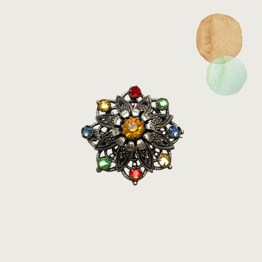 An Art Deco vintage brooch adorned with colourful foil-backed rhinestones. カラフルなフォイルバックラインストーンがあしらわれた、アールデコのヴィンテージブローチ。 