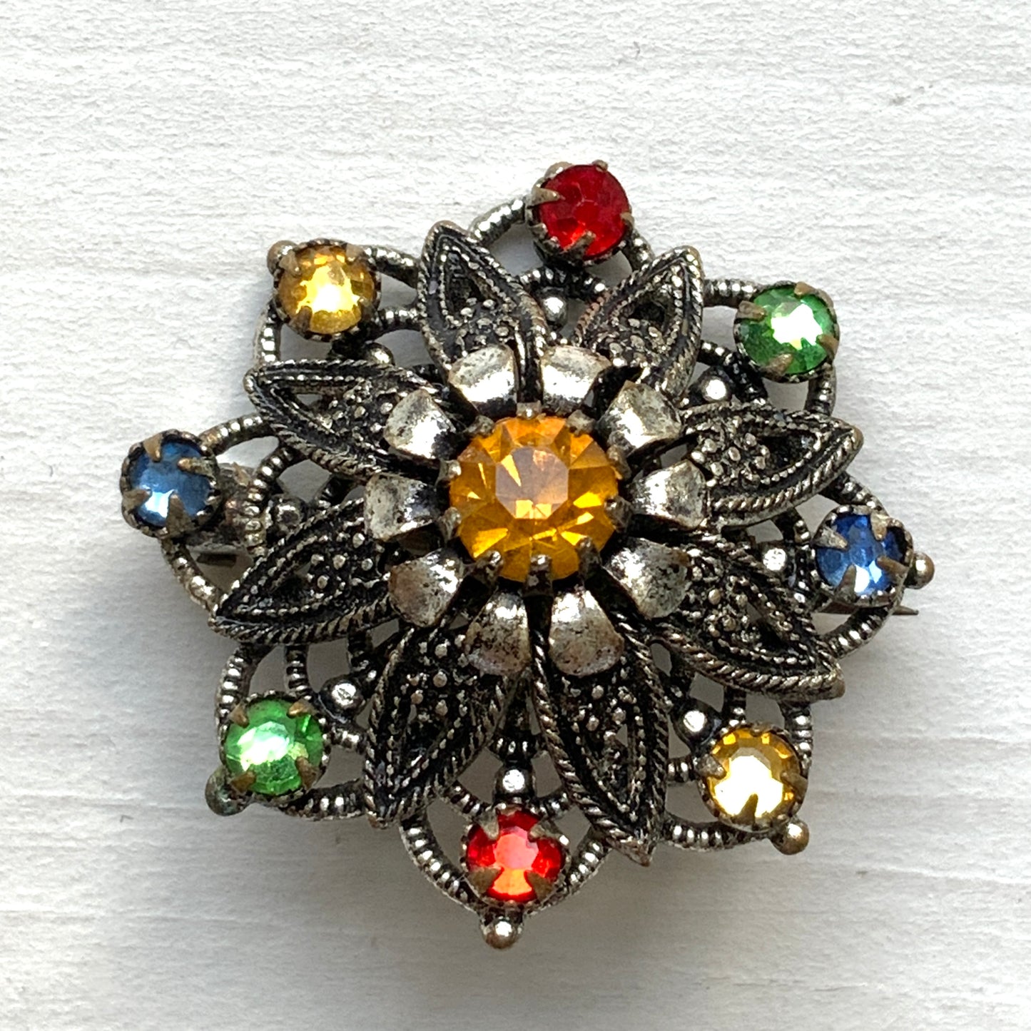 An Art Deco vintage brooch adorned with colourful foil-backed rhinestones. カラフルなフォイルバックラインストーンがあしらわれた、アールデコのヴィンテージブローチ。 
