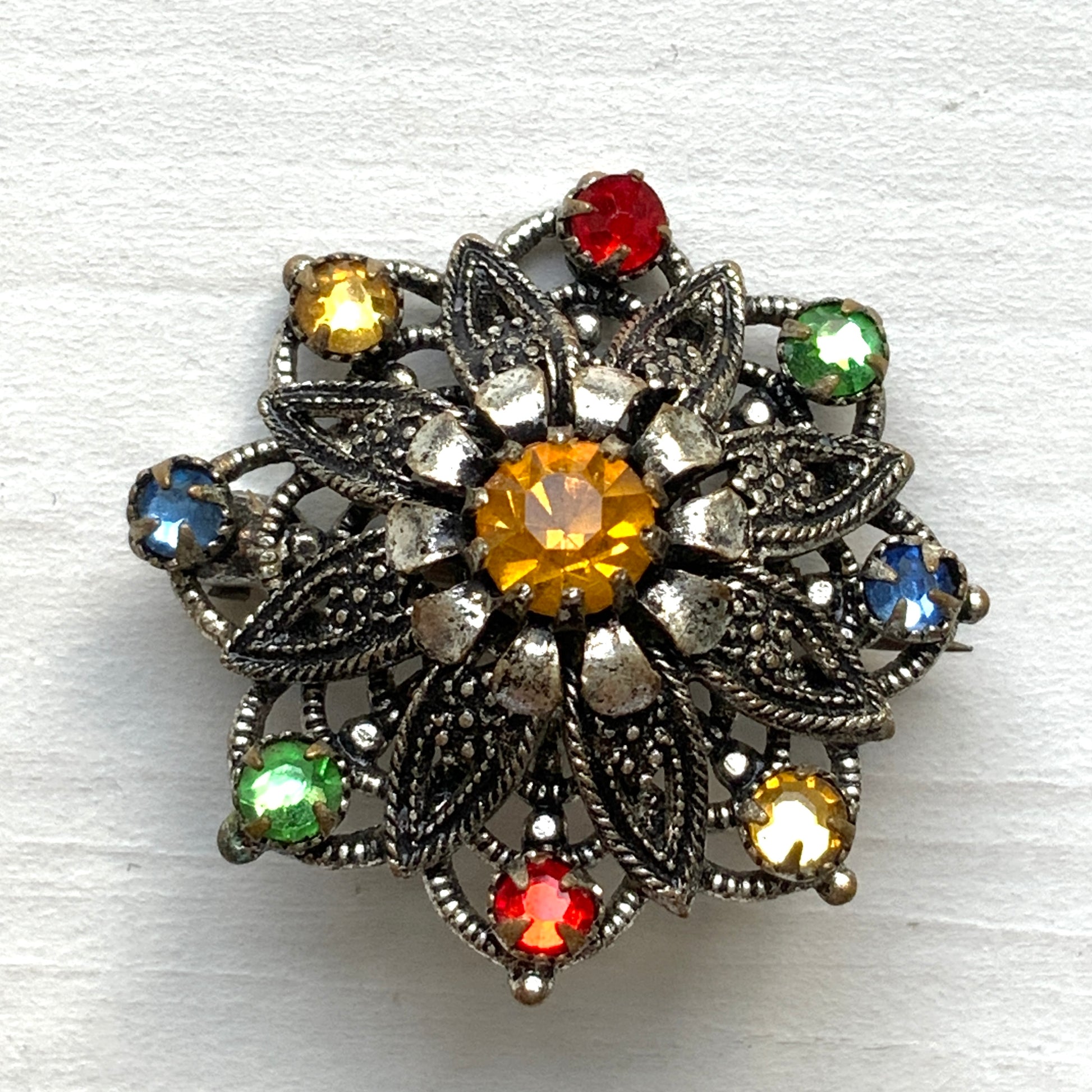 An Art Deco vintage brooch adorned with colourful foil-backed rhinestones. カラフルなフォイルバックラインストーンがあしらわれた、アールデコのヴィンテージブローチ。 