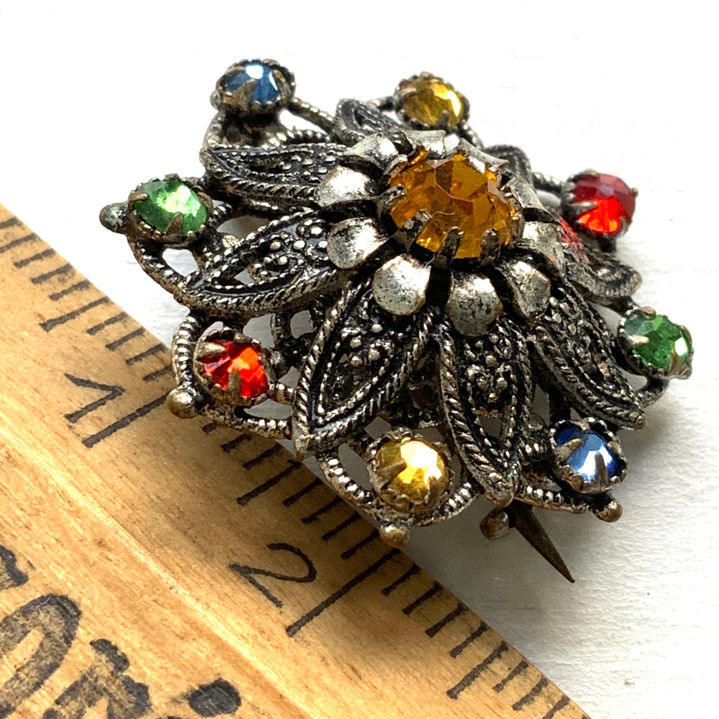 An Art Deco vintage brooch adorned with colourful foil-backed rhinestones. カラフルなフォイルバックラインストーンがあしらわれた、アールデコのヴィンテージブローチ。 