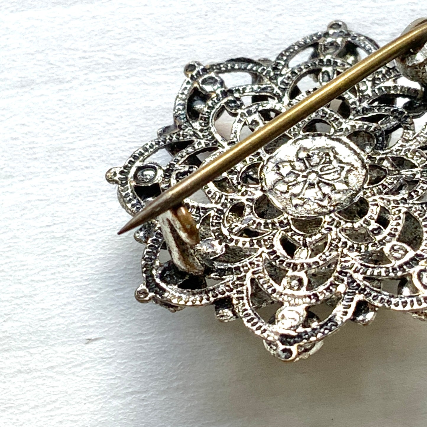 An Art Deco vintage brooch adorned with colourful foil-backed rhinestones. カラフルなフォイルバックラインストーンがあしらわれた、アールデコのヴィンテージブローチ。 