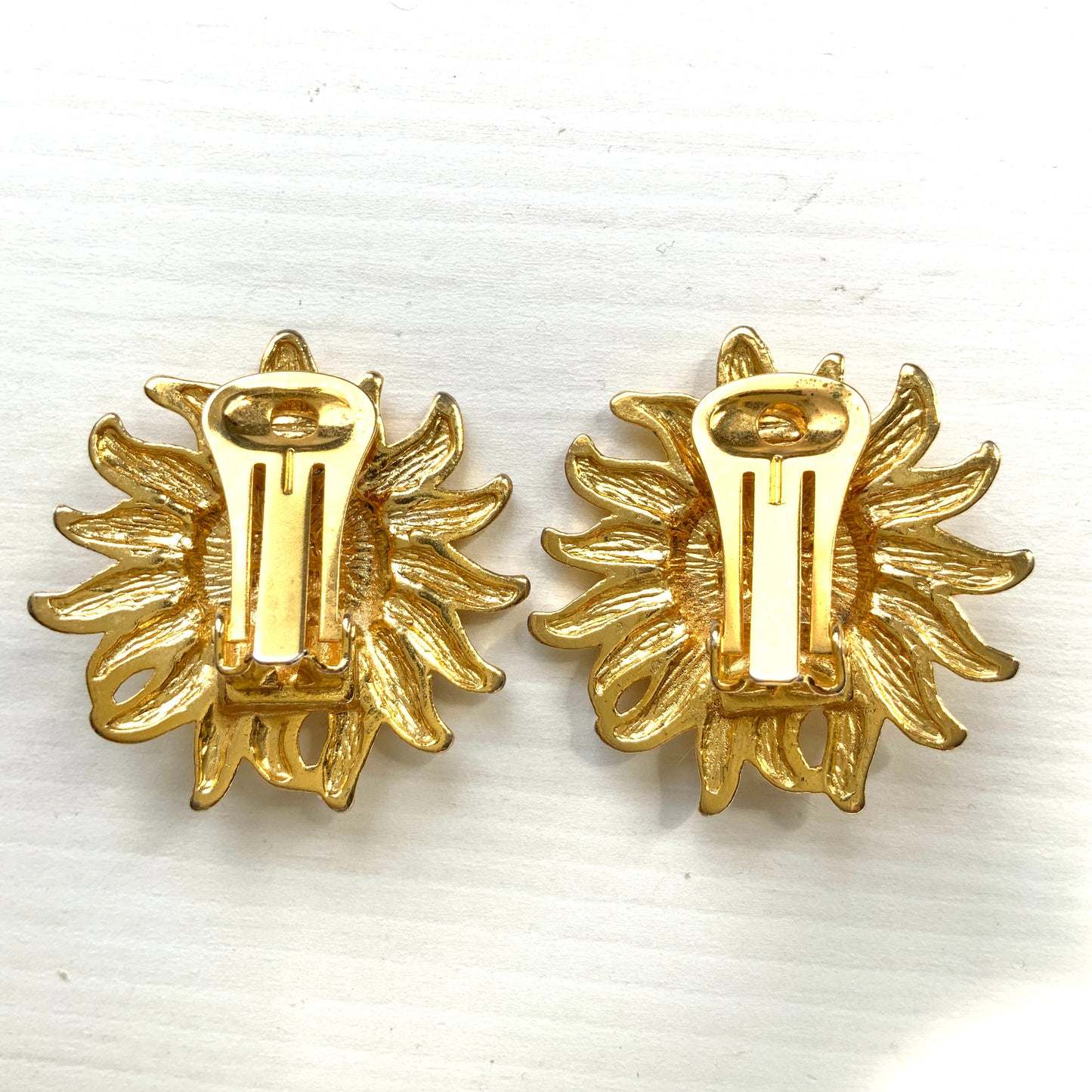 A charming pair of vintage Versace clip-on earrings featuring a gently smiling sun. 穏やかな微笑みをたたえた太陽の、ヴェルサーチのヴィンテージクリップイヤリング。